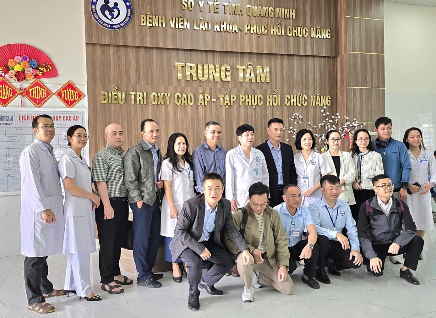 Phó Giáo sư, Tiến sỹ Lương Tuấn Khanh, Giám đốc Trung tâm Phục hồi chức năng, Bệnh viện Bạch Mai (Người đứng thứ 6 từ phải sang) cùng các thành viên trong đoàn tham quan Trung tâm điều trị oxy cao áp đa chỗ tại Bệnh viện Lão khoa – phục hồi chức năng Quảng Ninh.