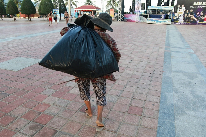 Bà Ni với túi phế liệu nhặt cả đêm ở Công Viên Biển Đông, khi trời đã sắp rạng đông.