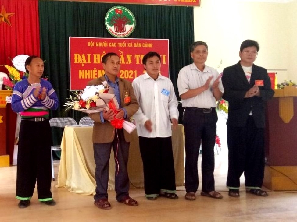 Ông Tráng A Thông (thứ hai từ trái sang) nhận hoa chúc mừng của lãnh đạo xã Bản Công, huyện Trạm Tấu, tỉnh Yên Bái