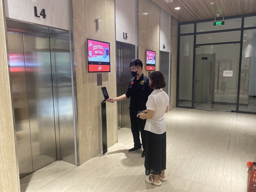 Nhân viên bảo vệ hướng dẫn khách đến thăm đi lên căn hộ. Ảnh TL