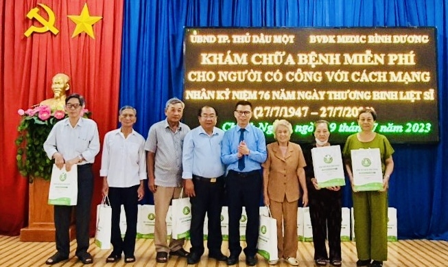 Đại diện Phòng LĐTBXH TP.TDM và Giám Đốc Bệnh viện Medic trao quà cho Người có công Cách mạng