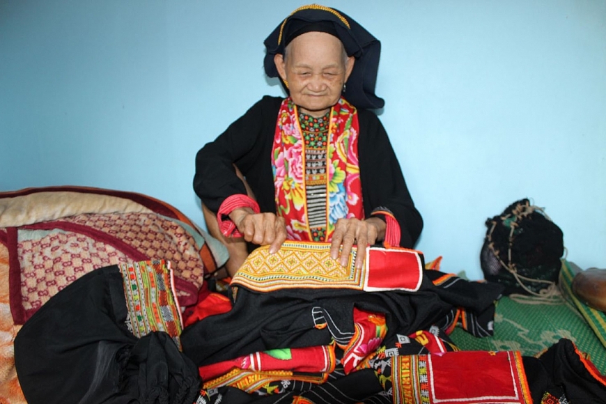 Bà Triệu Thị Hoà đang giới thiệu về trang phục may trang phục truyền thống của dân tộc mình.