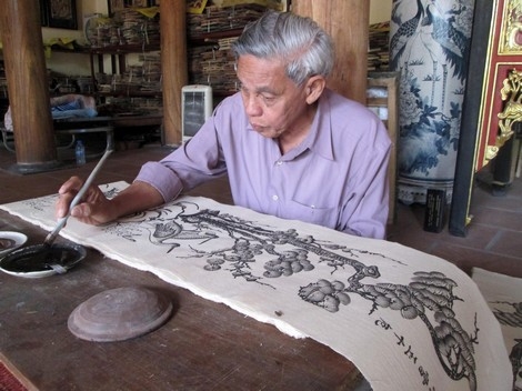 Nghệ nhân cao tuổi Nguyễn Đăng Chế bên tác phẩm tranh dân gian Đông Hồ