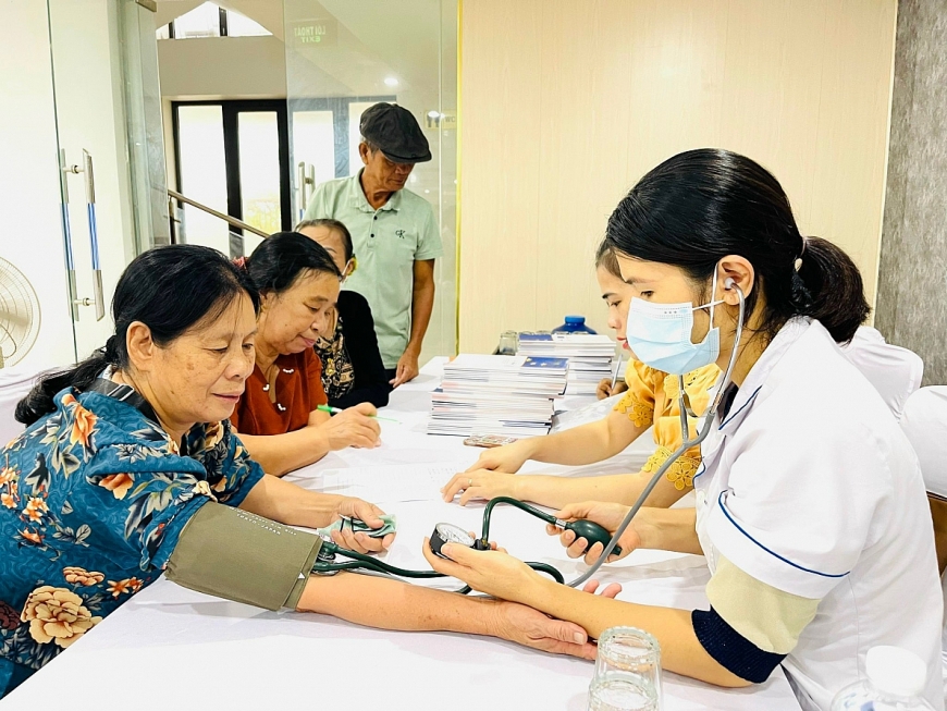 Các y, bác sĩ tiến hành đo huyết áp cho NCT tại lớp tập huấn