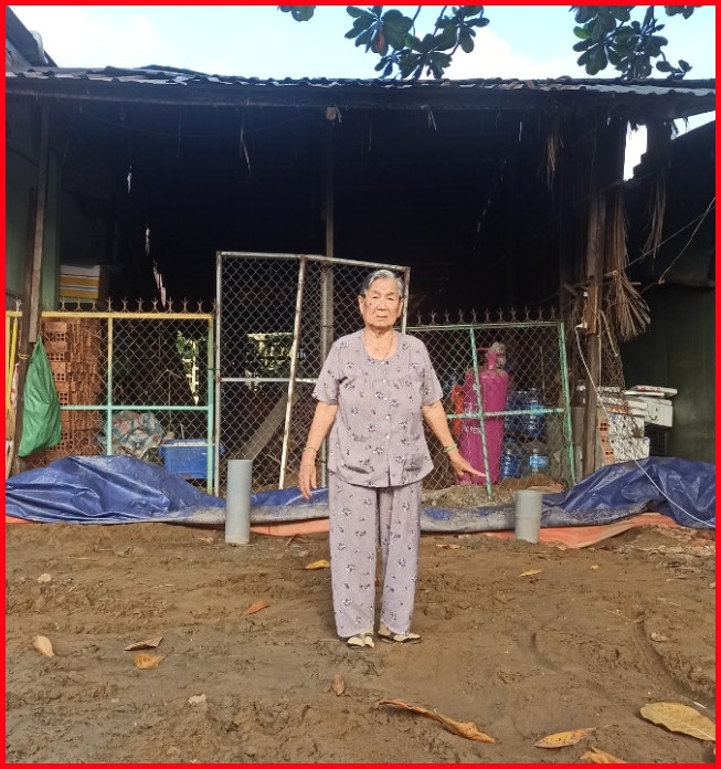 Cụ Nguyễn Thị Mười đứng trước phần đất cất căn nhà 36m2 từ năm 1992.