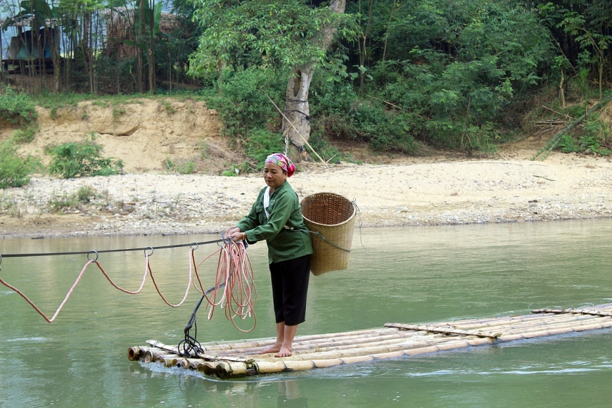 Bà Lò Thị Khắn đu dây kéo bè qua sông Luồng. Ảnh 2: Bà Lương Thị Thời ngồi bè mảng đu dây qua sông Luồng.