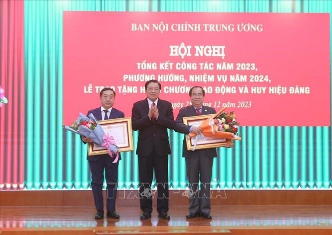 Đồng chí Phan Đình Trạc, Uỷ viên Bộ Chính trị, Bí thư Trung ương Đảng, Trưởng Ban Nội chính Trung ương trao Huân chương Lao động hạng Nhì cho các cá nhân. Ảnh: Phương Hoa/TTXVN