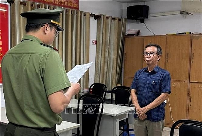 Cơ quan An ninh điều tra Công an Thành phố Hồ Chí Minh tống đạt các quyết định và lệnh đối với bị can Nguyễn Quang Thông, nguyên Tổng Biên tập Báo Thanh Niên. Ảnh: TTXVN phát