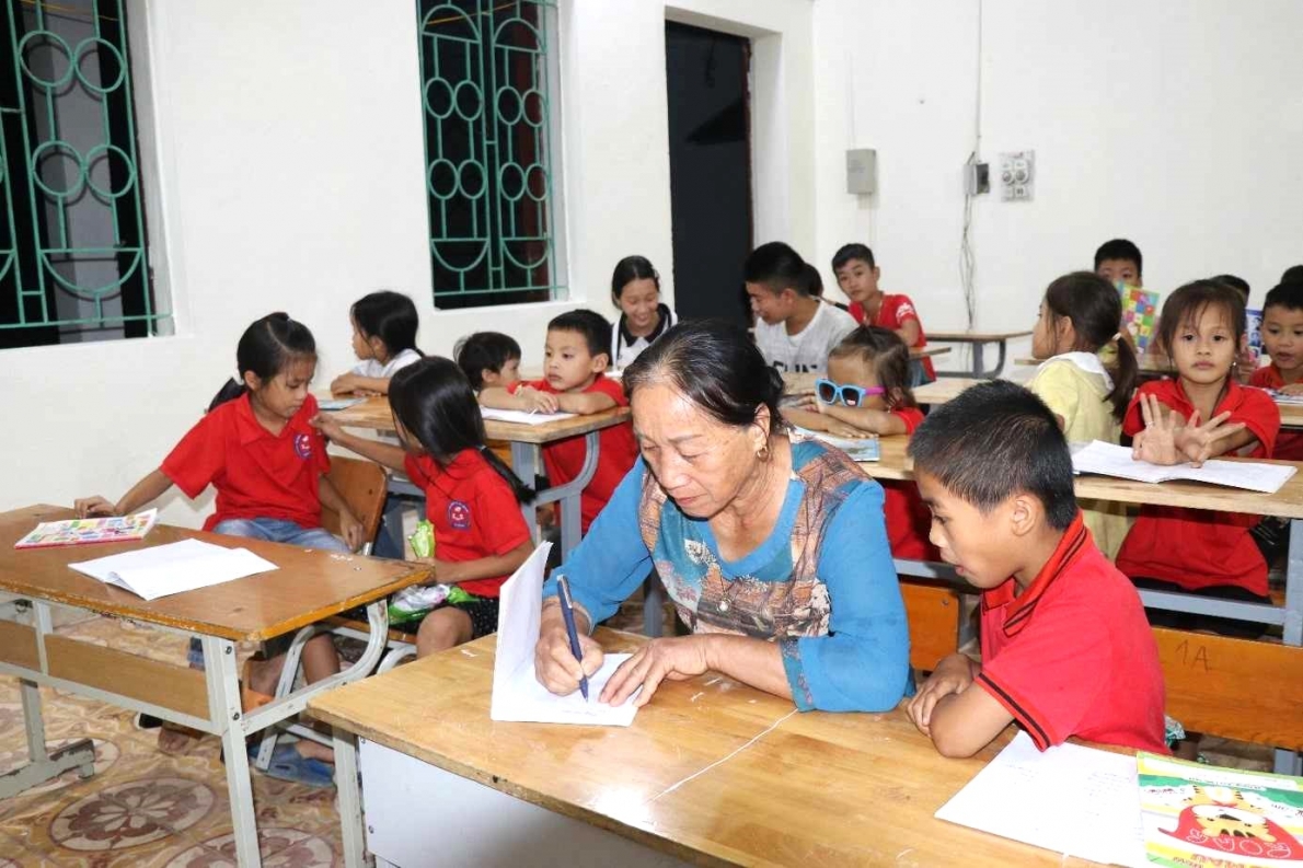 Bà Hoàng Thị Hợp, Chi hội trưởng NCT thôn Đồng Bây đồng hành cùng già làng Đảm Xuân Tình giảng dạy tiếng Sán Chí và Cao Lan cho các em học sinh. 