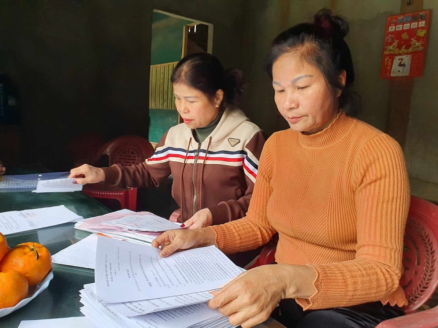 Bà Vũ Thị Mai bên cạnh hồ sơ, tài liệu đề nghị được minh oan.