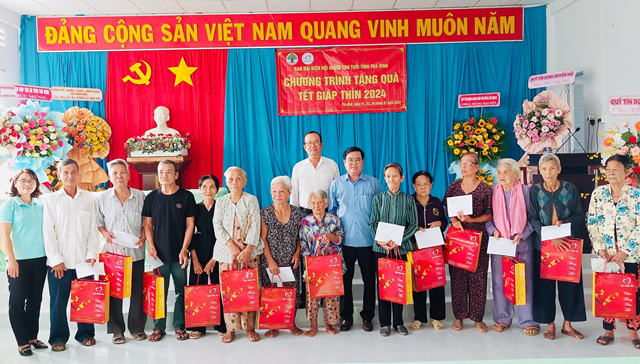 Ông Nguyễn Văn Long (người đứng giữa mặt áo xanh) Trưởng Ban Đại diện Hội NCT tỉnh Trà Vinh tặng quà Tết cho NCT có hoàn cảnh khó khăn tại huyện Cầu Ngang.