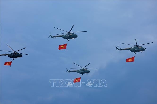 Máy bay trực thăng mang cờ Đảng, cờ Tổ quốc bay qua Lễ đài. Ảnh: Dương Giang/TTXVN