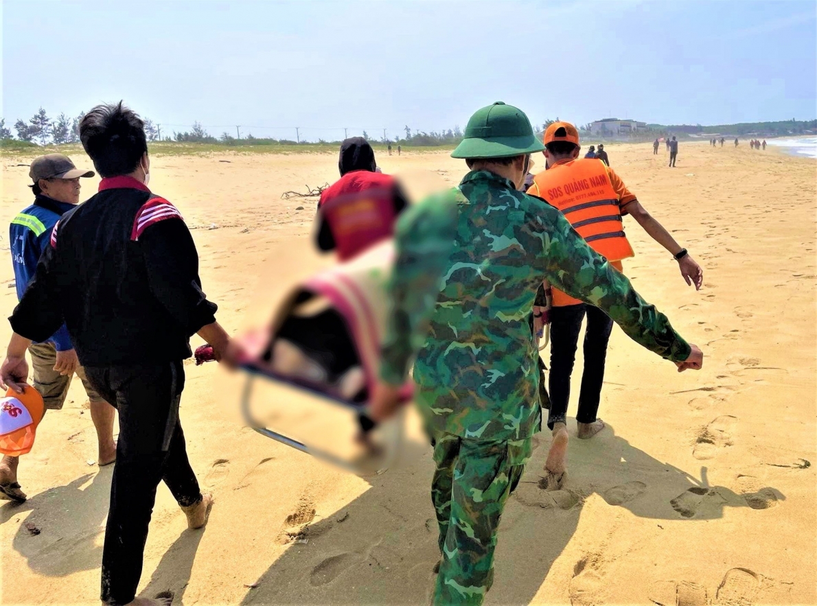 Lực lượng chức năng vớt đưa thi thể em H. lên bờ. 