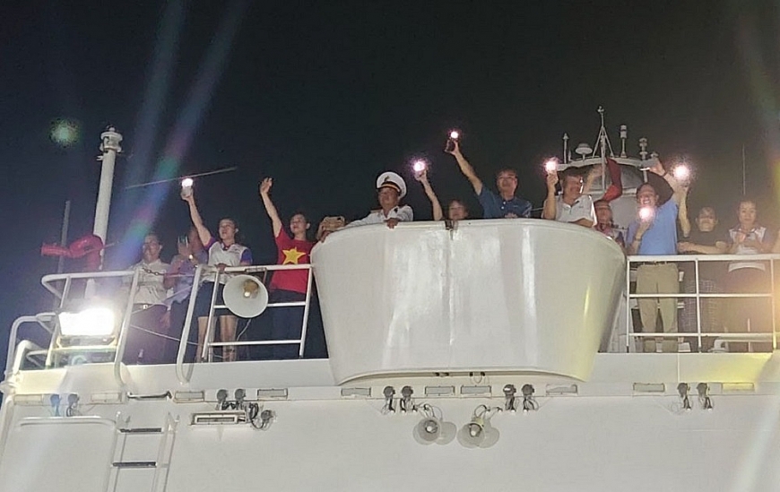 Trong màn đêm tối, những ánh đèn flash điện thoại được bật lên để vẫy chào tạm biệt quân dân trên đảo Trường SaNhững cái vẫy tay tạm biệt, những lời hát trao đi, gửi lại hẹn ngày trở lại với Trường Sa