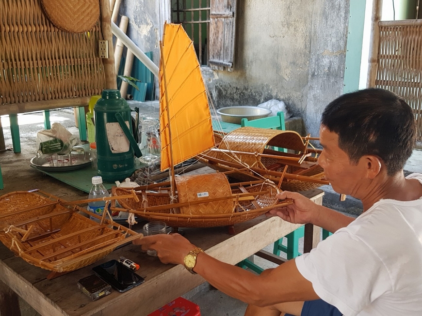 Ông Nguyễn Anh Sáu và những sản phẩm quà lưu niệm là những chiếc thuyền nan được chế tác từ đôi bàn tay tài hoa của ông.