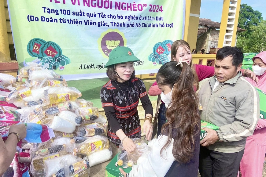 Chị Loan cùng đại diện các ngành tặng quà bà con bản Sê Sáp (huyện Ka Lừm, tỉnh Sê Kông, CHDCND Lào).