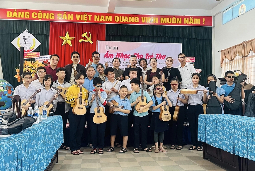 : Lương Hy (áo trắng) cùng các nhà hảo tâm tặng đàn cho các em khiếm thị