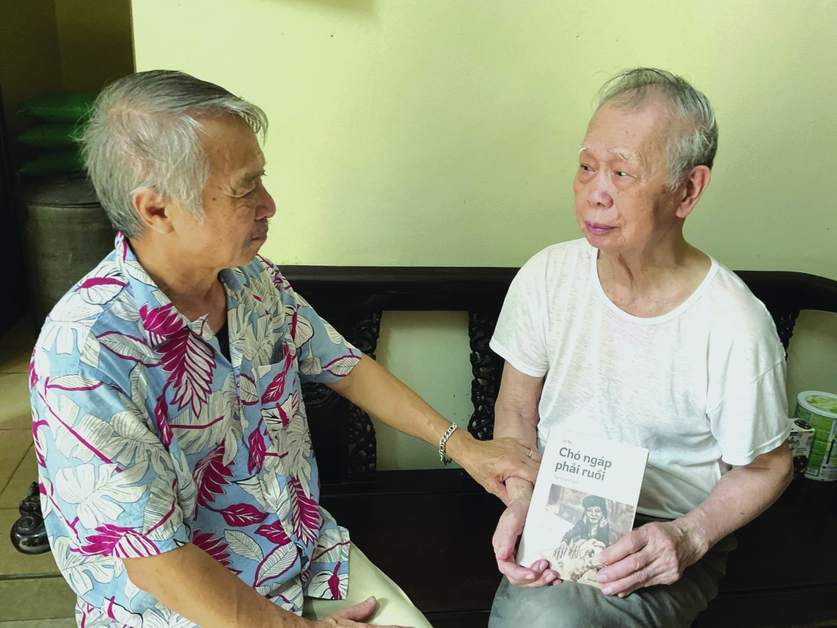 Nhà văn Lê Tự (người mặc áo hoa) tặng sách cho nhà văn Nguyễn Minh Thắng.