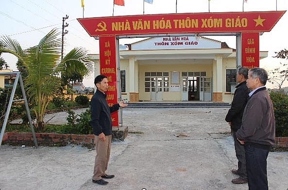 Ông Trầm (bên phải) và NCT trao đổi về việc sửa lại nhà văn hoá thôn.