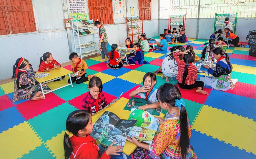 Các em học sinh thích thú khi đọc sách tại thư viện.