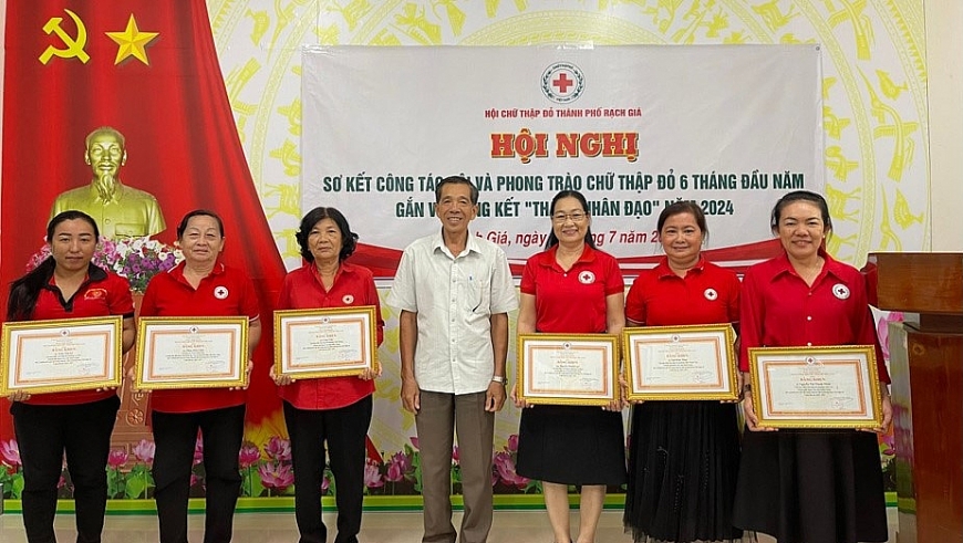 Bà Trần Thị Lệ (đứng hàng thứ 3 từ trái qua) nhận phần thưởng của Hội Chữ thập đỏ.