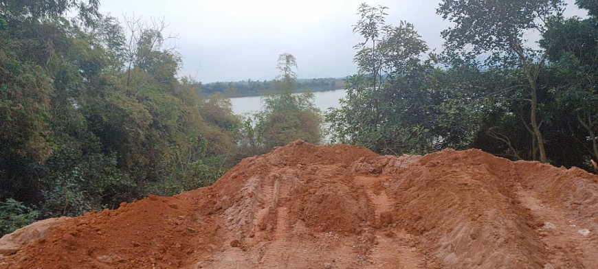 Bên phía trong tường rào là hàng nghìn mét khối đất đồi đã được đổ xuống hồ Đồng Mô.