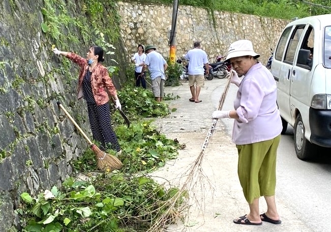 Bà Dương Thị Minh Hiền cùng hội viên NCT và nhân dân dọn dẹp vệ sinh môi trường