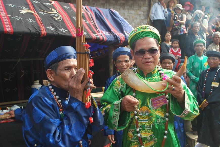  Già làng Alăng Bảy (bìa trái) đang thổi khèn trong Lễ hội của người Cơ Tu.