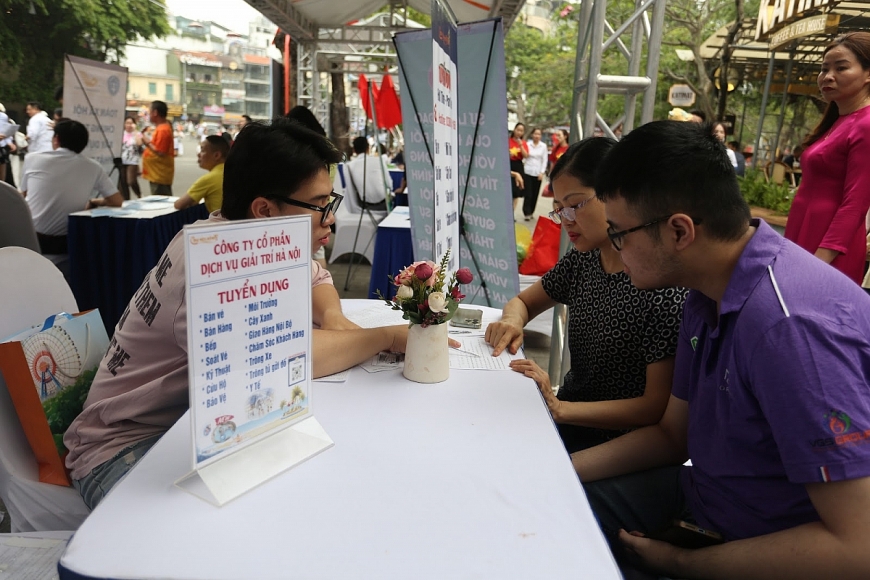 Cô My cùng con trai (bên phải ảnh) trò chuyện với nhà tuyển dụng để tìm kiếm cơ hội việc làm