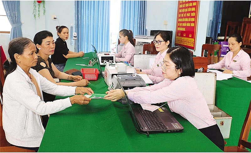 Ngân hàng Chính sách xã hội trao sổ vay vốn cho khách hàng vay vốn.