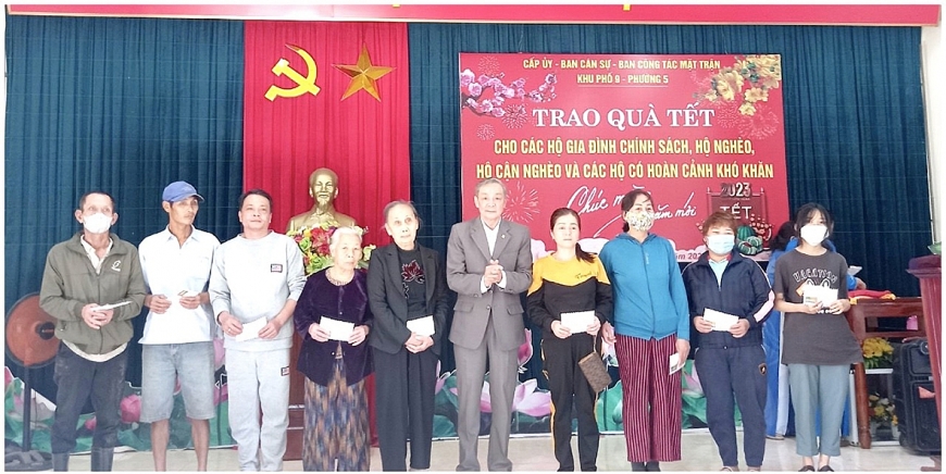 Ông Phạm Xuân Mượn (ở giữa) trao quà cho hộ nghèo, hộ cận nghèo nhân dịp Tết Nguyên đán.