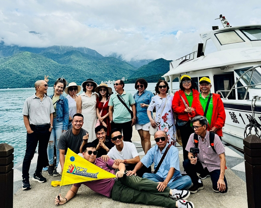 Tác giả (đứng bên phải) HDV cầm cờ phía trước tại Hồ Nhật Nguyệt (Đài Trung, Đài Loan)