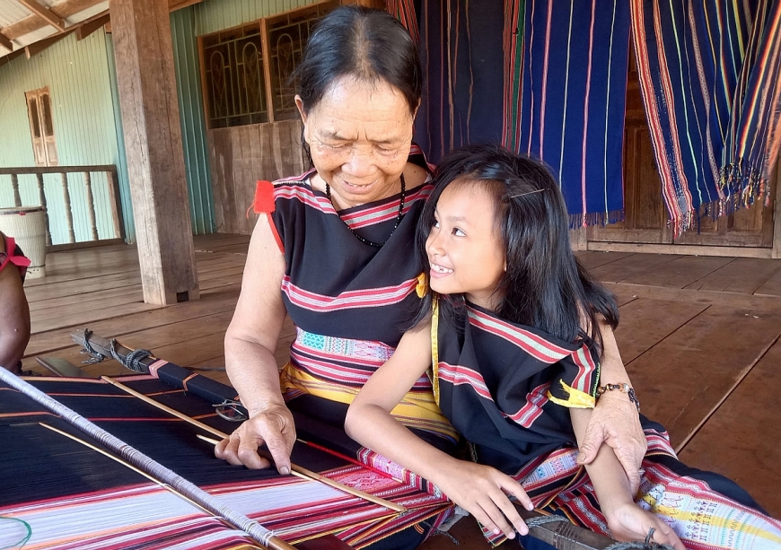 Nghệ nhân Rơ Châm Monh đã dệt nên biết bao câu chuyện của làng trên từng tấm vải.