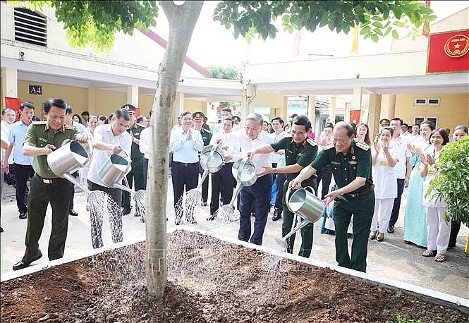 Tổng Bí thư Tô Lâm và các đại biểu trồng cây lưu niệm tại Trung tâm Điều dưỡng thương binh Thuận Thành. Ảnh: Thống Nhất/TTXVN