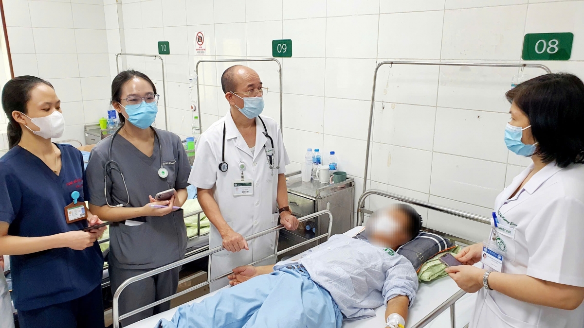 PGS.TS Đỗ Duy Cường, Viện trưởng Viện Y học Nhiệt đới Bạch Mai thăm khám cho bệnh nhân 38 tuổi trong chùm ca bệnh liên cầu khuẩn lợn do ăn tiết canh