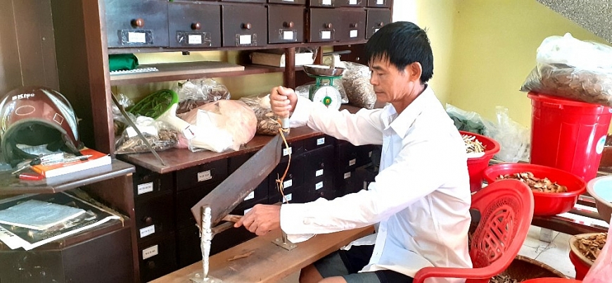 Lương y Đinh Văn Hùng hỏi bệnh để bốc thuốc Nam cho người bệnh.