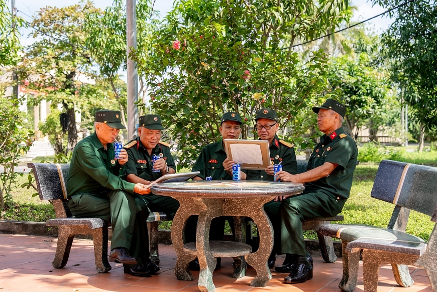 Các bác cựu chiến binh chăm chú đọc những dòng chữ nhỏ, được các em gửi kèm trong mỗi bức tranh (Ảnh: Duy Cường)