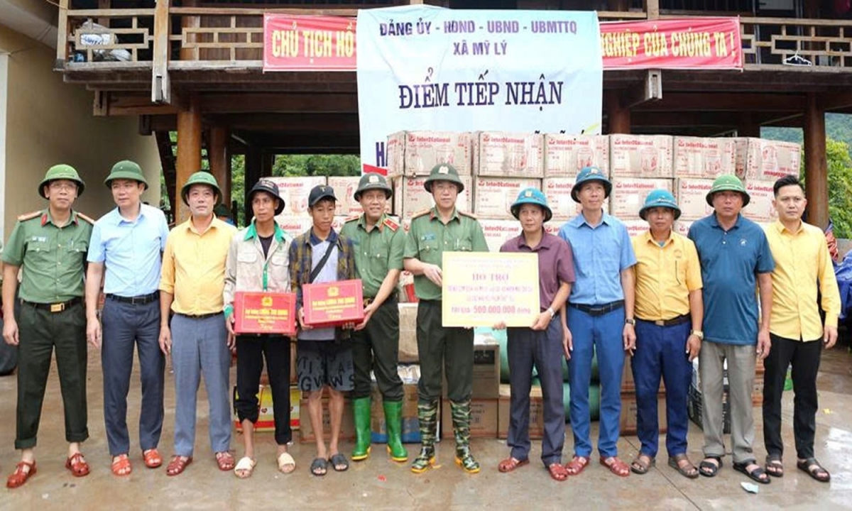 Thiếu tướng Nguyễn Hồng Nguyên và Đại tá Đinh Việt Dũng, Giám đốc Công an tỉnh Nghệ An trao quà của Đại tướng Lương Tam Quang, Bộ trưởng Bộ Công an cho các hộ bị thiệt hại nặng nề do mưa lũ.