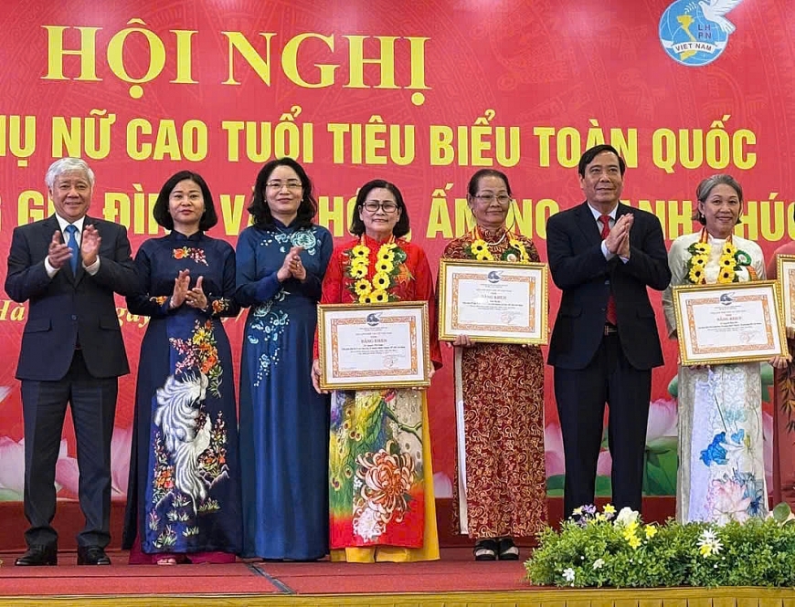 Bà Nguyễn Thị Chăm (đứng giữa) nhận Bằng khen do có thành tích trong xây dựng gia đình văn hoá, ấm no, hạnh phúc.