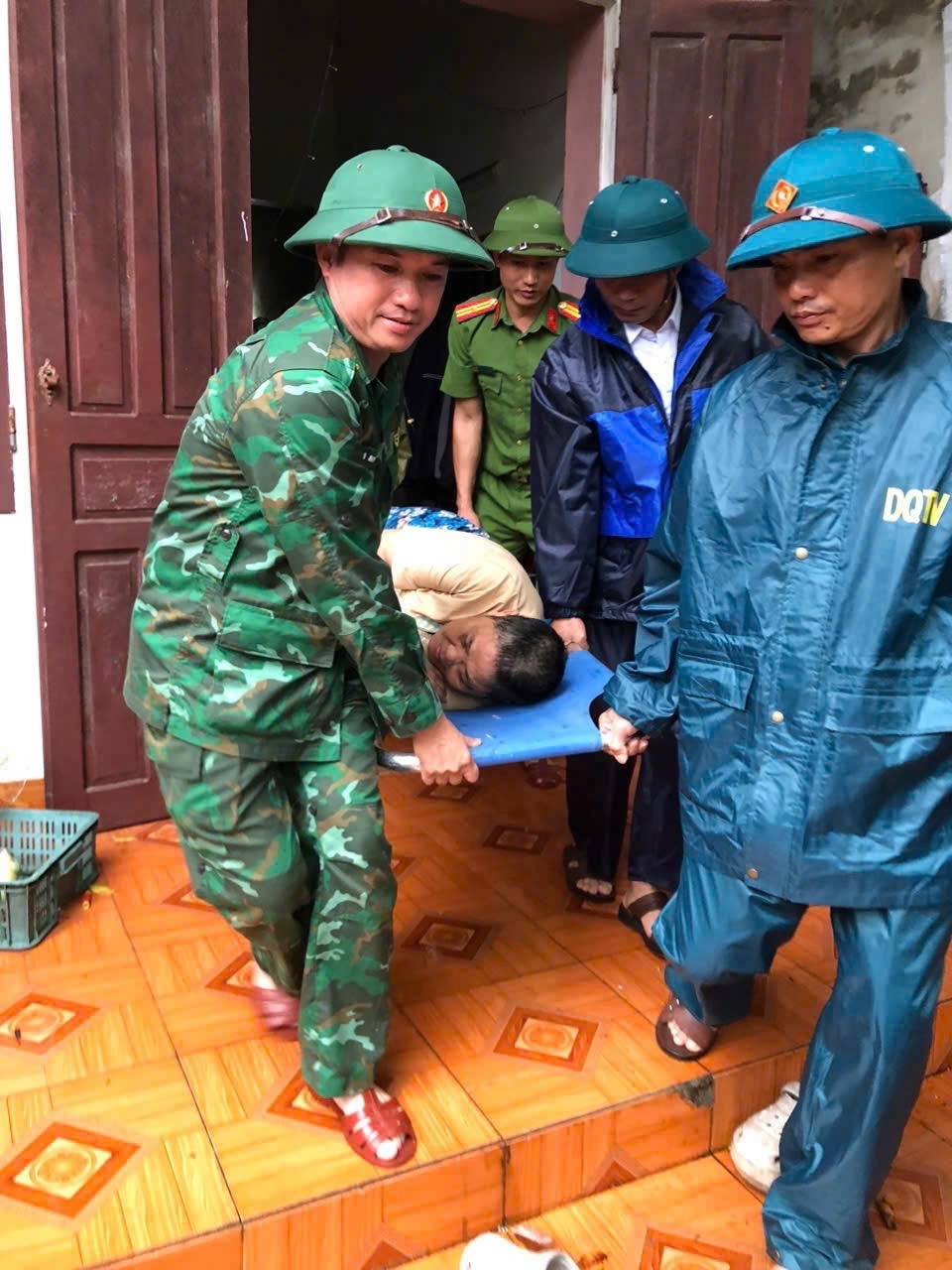 Cán bộ Đồn Biên phòng Hải Hòa và lực lượng chức năng giúp người dân di dời đến nơi an toàn.