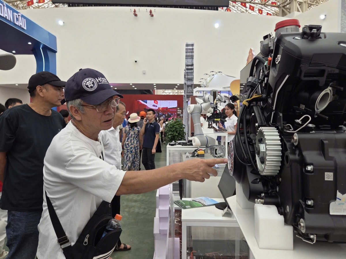 Một cụ cao tuổi đang xem máy móc ở khu triển lãm