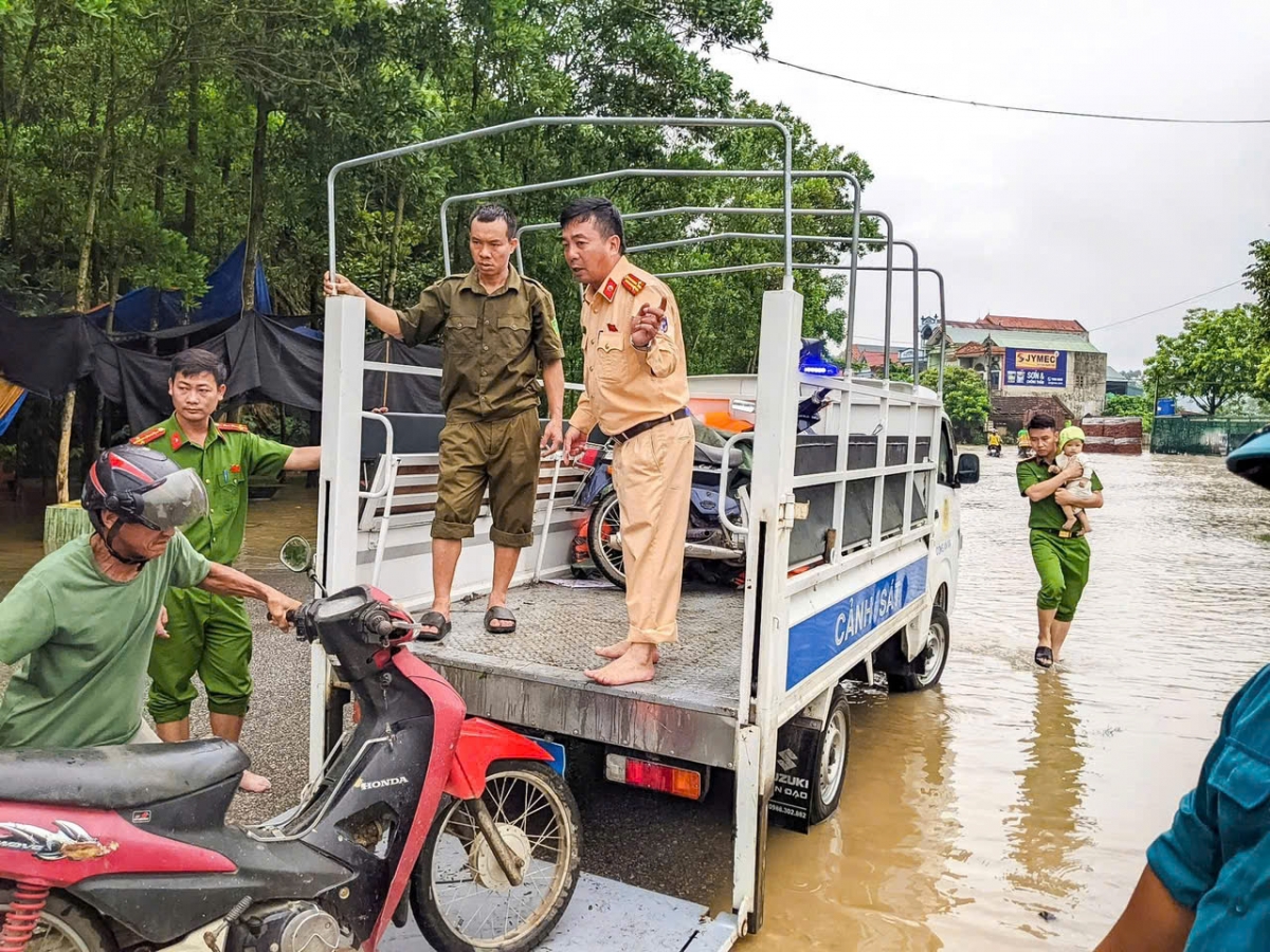 Lực lượng Cảnh sát giao thông hỗ trợ người dân di chuyển qua các điểm ngập lụt an toàn