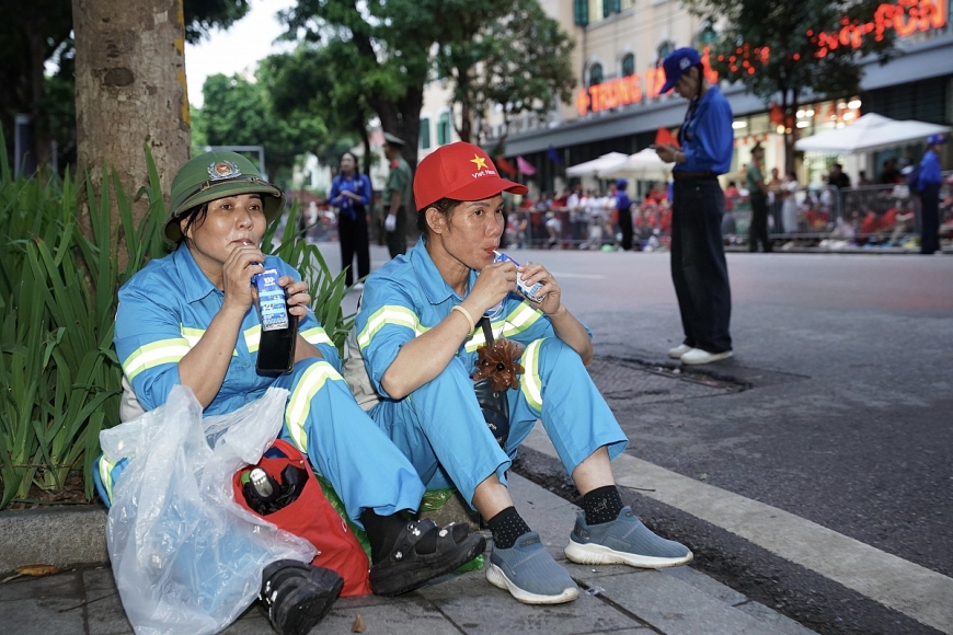 Phút nghỉ ngơi và tiếp thêm chút năng lượng bằng sữa tươi Vinamilk của các chị góp phần quan trọng để đại lễ diễn ra với những tuyến đường sạch sẽ, ngăn nắp. (Ảnh: Vi Nam) 