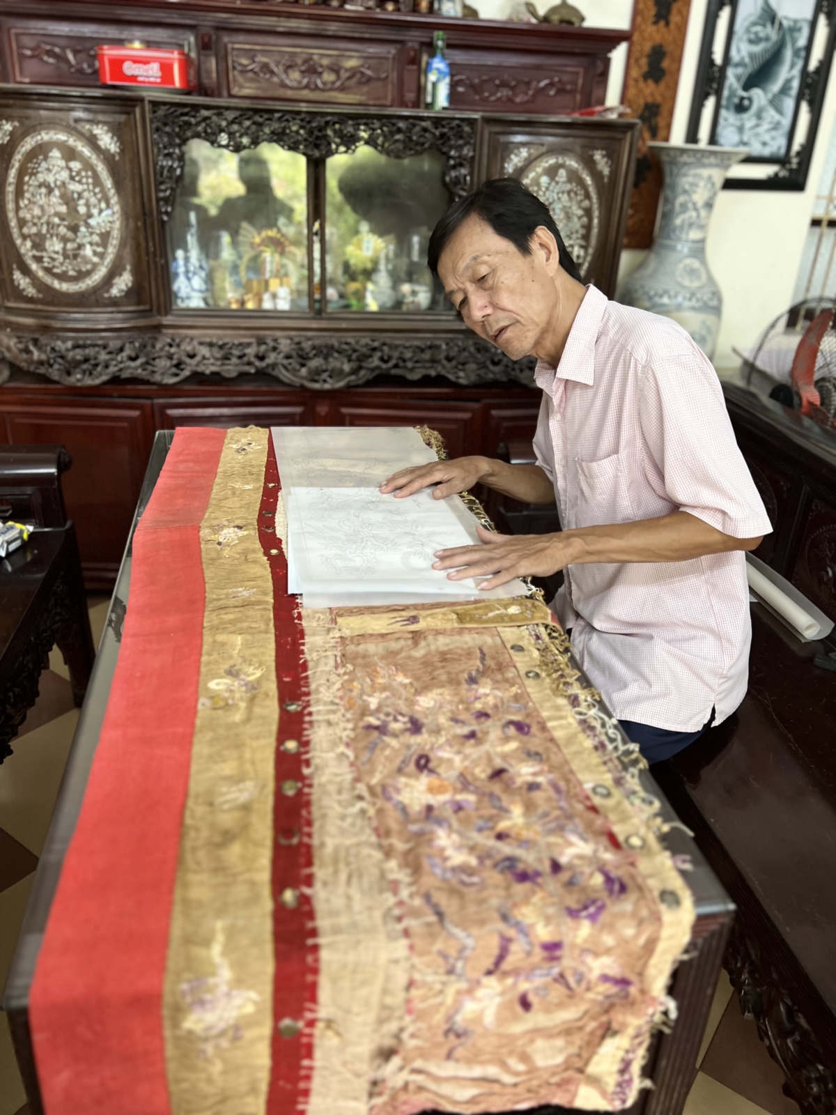 Nghệ nhân Vũ Thanh Luân đang nghiên cứu để phục chế một mẫu y môn cổ giúp một vị khách hàng ở Nghệ An