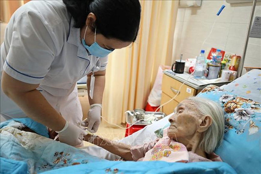 Một bác sĩ đang thăm khám cho bệnh nhân tại giường bệnh, thể hiện tinh thần tận tâm và quan tâm đến nhu cầu đặc biệt của người cao tuổi.