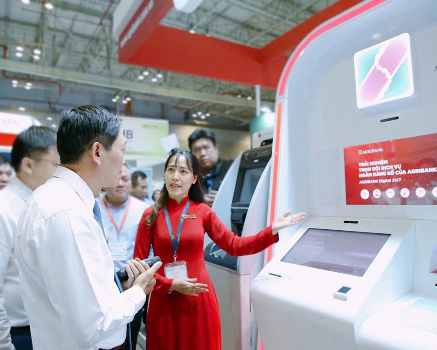 Cán bộ, nhân viên Agribank hướng dẫn khách hàng trải nghiệm gói dịch vụ ngân hàng số.