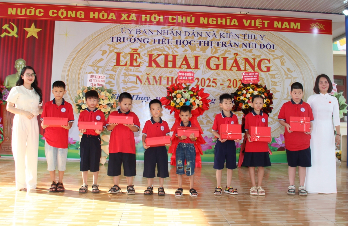 Đại diện nhà trường và Hội phụ huynh trao quà cho các học sinh.