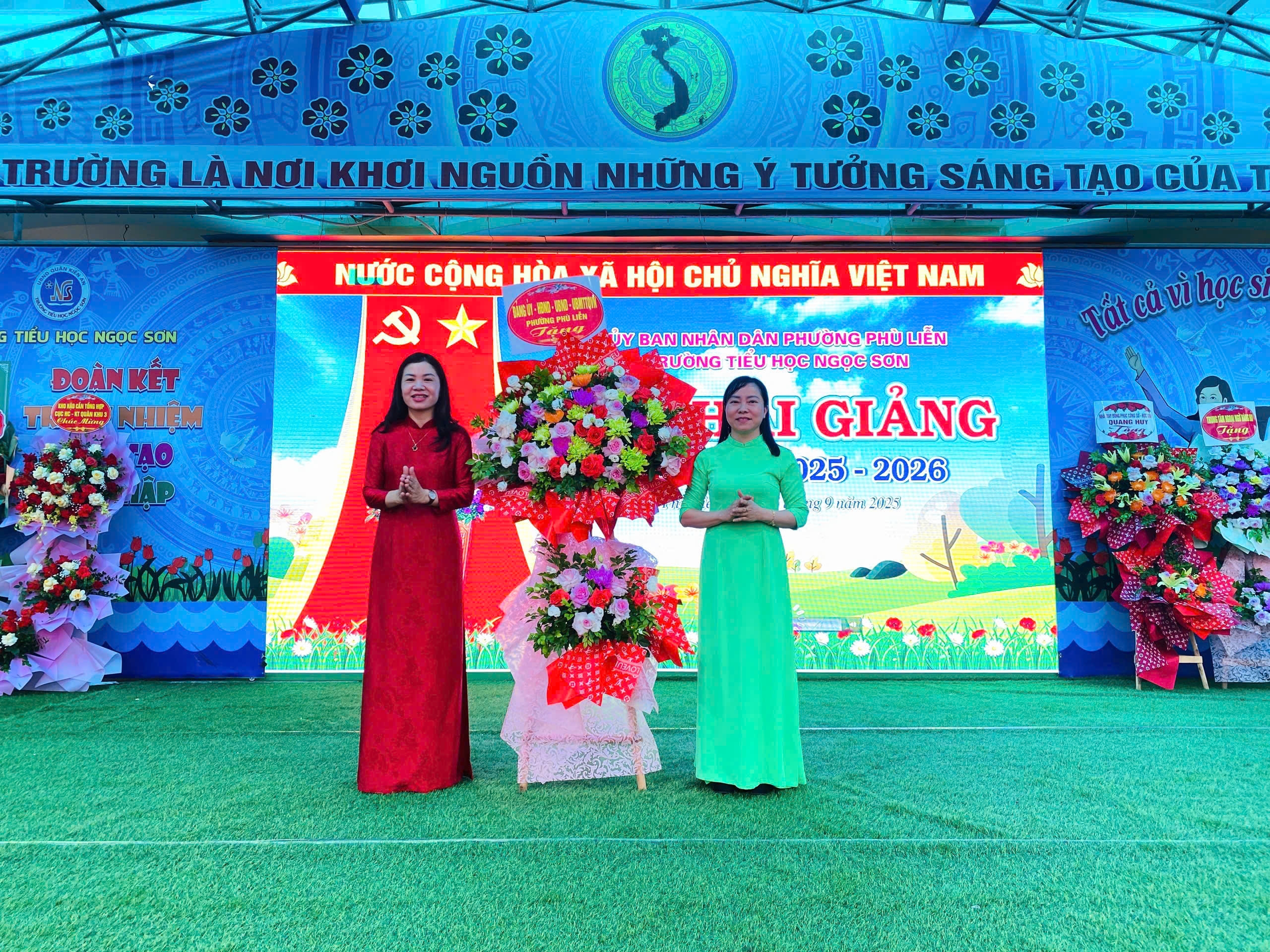 Cô Bùi Thị Phi Nga, hiệu trưởng trường Tiểu học Ngọc Sơn nhận hoa chúc mừng của Phường Phù Liễn.