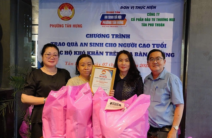 Bà Phạm Thị Hạnh Tư (ngoài cùng bên trái), Chủ tịch UBMTTQ Việt Nam phường Tân Hưng, Giám đốc Trung tâm An sinh xã hội trao thư cảm ơn đơn vị tài trợ