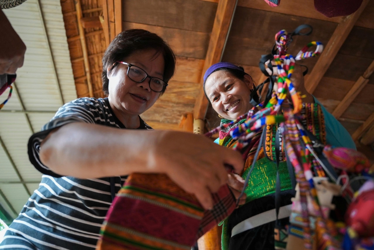 Nghệ nhân người Thái giới thiệu sản phẩm thủ công và chia sẻ câu chuyện văn hóa với du khách, tạo nên không gian giao lưu gần gũi tại triển lãm “Man Kháu – Rice Up”.